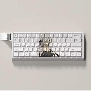 May include: A white mechanical keyboard featuring Japanese characters and an anime-style graphic. The keyboard has white keycaps and a white frame. The anime character is centrally positioned on the keyboard.