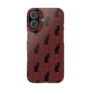 Puede incluir: Una funda de teléfono con un patrón repetido de siluetas de gatos negros sobre un fondo rojo oscuro. La funda tiene un acabado brillante y un recorte para la cámara.