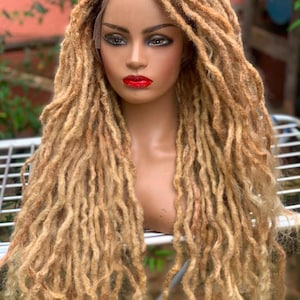May include: A lace front wig featuring long, textured blonde dreadlocks with darker brown roots. The hair is styled in a voluminous, layered cut that falls past the shoulders, showcasing a multi-tonal color blend from dark brown at the scalp to light blonde.