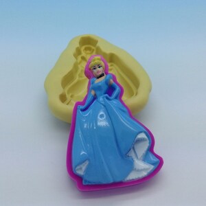 May include: A blue silicone mold of a princess in a blue gown with a pink bodice and a crown. The mold is on a white surface.