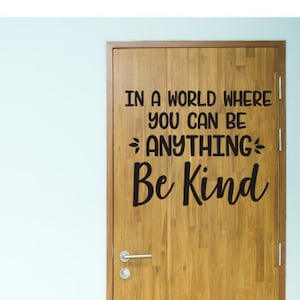 May include: A wooden door with a black vinyl decal that reads "In a world where you can be anything, be kind."