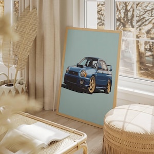 May include: A framed print featuring a blue sports car with gold wheels, set against a light blue background. The car is depicted in a stylized illustration. The print is displayed in a room with natural light and neutral decor.