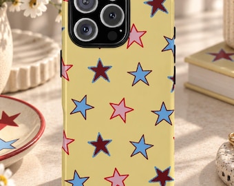 May include: A yellow smartphone case featuring a repeating pattern of five-pointed stars in shades of light blue, dark red, and pink. The case has a black camera cutout area at the top left, designed to fit a phone with a triple-lens camera system.
