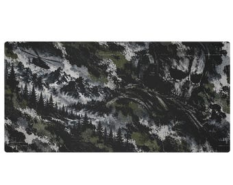 May include: A rectangular desk mat featuring a dark, gritty illustration of a skull wearing a headset, set against a mountainous landscape with pine trees and a helicopter in the sky. The color palette consists of black, white, and olive green tones.