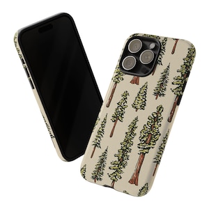 May include: A smartphone and a phone case with a nature-themed design. The case features a repeating pattern of green and brown trees on a beige background. The phone is black.