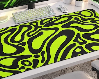 May include: A rectangular desk mat featuring a high-contrast pattern of irregular, fluid black shapes set against a vibrant neon green background. The mat has rounded corners and a smooth, flat surface designed for computer peripherals.