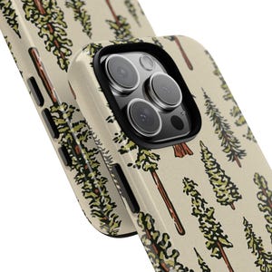May include: Two phone cases with a repeating pattern of stylized trees in brown, green, and beige. The cases have a glossy finish and a black camera lens protector.
