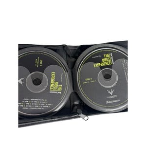 Peut inclure: Un étui noir pour CD contenant deux disques intitulés "The Bible Experience". Le disque 3 comprend Matthieu 28 et Marc 11. Le disque 4 comprend Marc 12 et Luc 5. Les disques sont noirs avec du texte blanc.