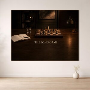 Peut inclure: Une impression d'art mural montrant un bureau en bois sombre avec un jeu d'échecs, un carnet ouvert avec un stylo et une lampe de bureau. Le texte THE LONG GAME est centré sous l'échiquier. La scène est faiblement éclairée par une lumière chaude.