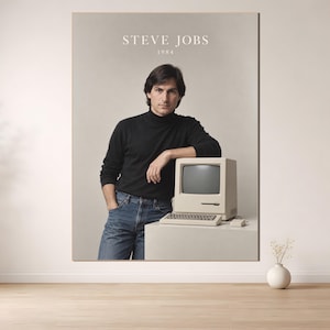 Peut inclure: Une affiche verticale présentant un portrait de Steve Jobs en 1984. Il porte un col roulé noir et un jean bleu, appuyé sur un ordinateur Macintosh vintage beige avec un clavier et une souris. Le texte STEVE JOBS 1984 est imprimé en haut.