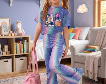 May include: A young person wearing a matching two-piece outfit. The top is a short-sleeved crop top with a graphic print, and the pants are flared. The outfit features a rainbow gradient design with a starry pattern. A pink handbag is held in the hand.