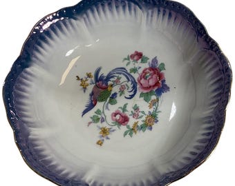 Bol antiguo de porcelana checoslovaca con diseño de ave del paraíso y borde festoneado azul.