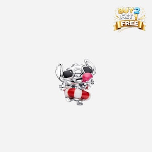 May include: A silver charm featuring a cartoon character wearing sunglasses and a pink tongue sticking out. The character is holding a red and white striped floatation device. The charm has a Buy 2 Get 1 Free banner.