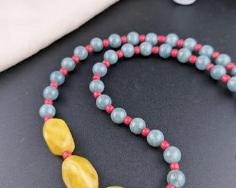 Collana asimmetrica in giada birmana, resina gialla, perline verdi naturali, dettagli in corallo rosso, gioiello boho.