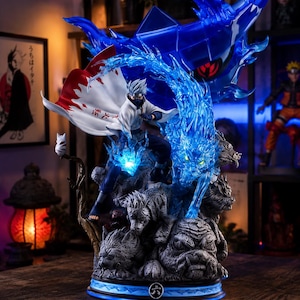 May include: A detailed figurine of a character in a white coat and cape, with blue energy effects and a large blue creature. The base is gray with detailed carvings and a blue light. The cape has Japanese text.