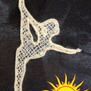 May include: White lace cutout of a figure in a contorted pose, reminiscent of a dancer or gymnast. The figure is against a black background.
