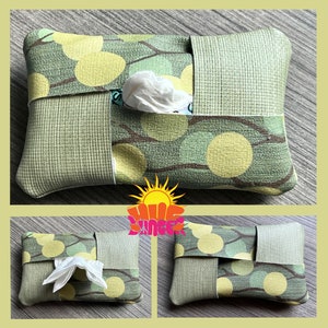 May include: A green and yellow patterned tissue box cover with a white tissue inside. The cover has a woven texture and a design of branches and circles.
