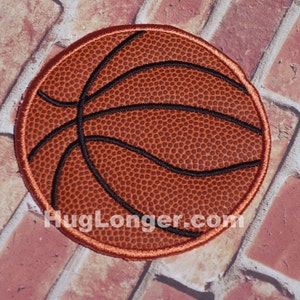May include: A brown and black basketball patch with a textured surface. The patch is round and has a black outline.