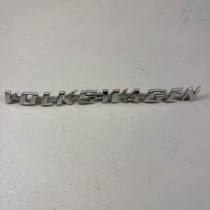 Emblema original VW de época, placa con el nombre Volkswagen en cromo, número de pieza 113853687B
