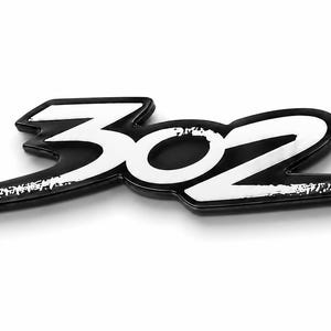 May include: A black and white emblem featuring the number 302 in a stylised, bold font. The design consists of white numerals with a black outline and a black background base, creating a high-contrast, layered appearance for this automotive badge.