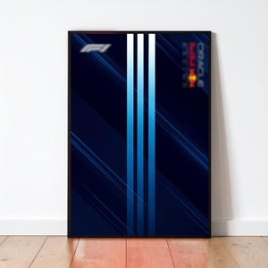 May include: A framed poster featuring a dark blue design with three vertical light blue stripes. The poster includes the Formula 1 logo and the Oracle Red Bull Racing logo. The background has diagonal blue lines.