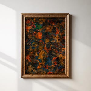 May include: A rectangular wall art piece featuring an abstract painting with a dark, textured background. The composition displays layered splotches of burnt orange, deep blue, and black paint, all enclosed within a simple, medium-toned wooden frame.