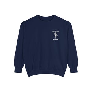 May include: Navy blue sweatshirt with white text and a medical symbol. The text reads "LMU-DCOM" above a caduceus symbol and the word "MEDICINE" below. The long-sleeved crew neck top is a solid color.