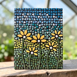 Peut inclure: Une œuvre d'art en mosaïque représentant trois fleurs jaunes avec des centres blancs et des tiges vertes. Le fond est composé de carreaux triangulaires bleus, turquoise et blancs. La mosaïque est posée sur un fond sombre, créant un design floral vibrant.