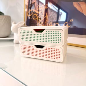 May include: A set of three ceramic mugs with a speckled, matte finish in cream, light grey, and dark grey. Each mug has a simple, minimalist design and a rounded handle.