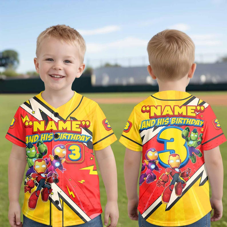 Puede incluir: Una camiseta de b&eacute;isbol amarilla y roja con el texto "NAME AND HIS BIRTHDAY" y el n&uacute;mero "3". La camiseta presenta ilustraciones de dibujos animados de superh&eacute;roes. La camiseta la lleva un ni&ntilde;o peque&ntilde;o.