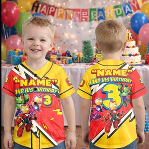 Puede incluir: Una camiseta de cumplea&ntilde;os amarilla y roja con el texto "NAME AND HIS BIRTHDAY" y el n&uacute;mero 3. La camiseta presenta gr&aacute;ficos de superh&eacute;roes de dibujos animados. La imagen muestra la parte delantera y trasera de la camiseta.