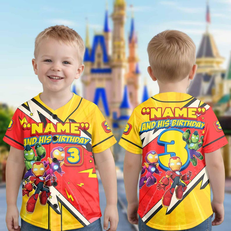 Puede incluir: Camiseta de b&eacute;isbol amarilla y roja con gr&aacute;ficos de Iron Man y otros superh&eacute;roes. La camiseta tiene el texto "NAME" y "AND HIS BIRTHDAY" con el n&uacute;mero "3". La camiseta la lleva un ni&ntilde;o peque&ntilde;o.