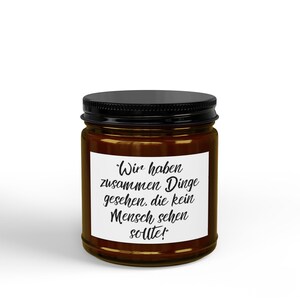 May include: A brown glass jar with a black lid. The jar has a white label with black cursive text that reads "Wir haben zusammen Dinge gesehen, die kein Mensch sehen sollte!"