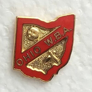 May include: A red and gold Ohio W.B.A. bowling pin lapel pin. The pin features a bowling pin with three holes and the text "Ohio W.B.A."