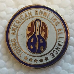 May include: A gold and purple pin with the text "Young American Bowling Alliance" around a bowling pin graphic.