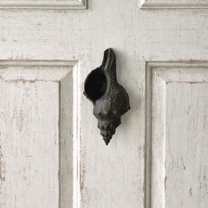 May include: A set of three ceramic mugs with a speckled, matte finish in cream, light grey, and dark grey. Each mug has a simple, minimalist design, ideal for coffee or tea.