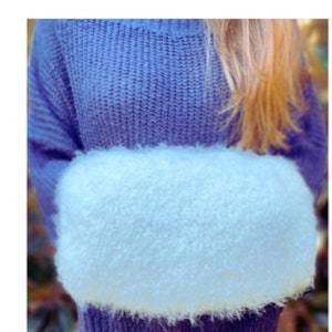 May include: A fluffy white faux fur hand warmer. The hand warmer is shaped like a rectangle and has a soft, fuzzy texture.