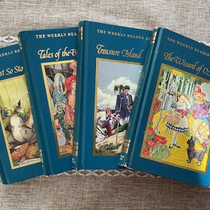 May include: A set of four teal hardcover books from The Weekly Reader Classics series. The titles include Just So Stories, Tales of the Brothers Grimm, Treasure Island, and The Wizard of Oz. Each book features a gold-bordered illustration on the front.