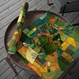 May include: A roll of wrapping paper and a wrapped gift with a colourful aerial view of fields in green, yellow, and orange. Scissors and tape are also on the table, all on a wooden surface.