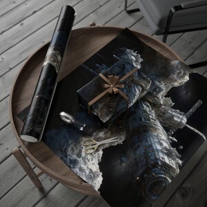 May include: A rolled-up poster and a wrapped gift with a brown ribbon sit on a wooden table. The poster and gift wrap feature a dark, space-themed design. A pair of gold scissors and a silver tape dispenser are also on the table.