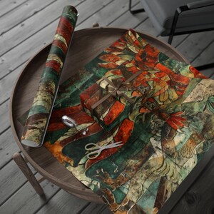 May include: A roll of wrapping paper and a wrapped gift with a brown ribbon sit on a wooden table. The paper features a detailed, colorful design with red, green, and gold hues. Scissors and tape are also on the table.