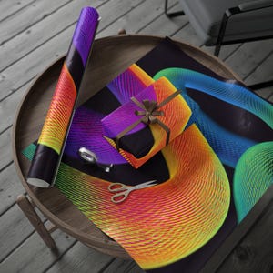 Pode incluir: Um rolo de papel de embrulho colorido e uma caixa de presente embrulhada com uma fita castanha estão sobre uma mesa de madeira. O papel de embrulho apresenta um gradiente vibrante de tons laranja, amarelo e roxo. Tesouras e fita adesiva também estão na mesa.