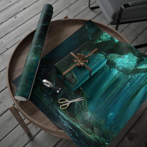 Puede incluir: Un rollo de papel de regalo turquesa y un regalo envuelto con una cinta marrón están sobre una mesa de madera. El papel de regalo presenta una escena de bosque con rayos de luz. Un par de tijeras doradas y un dispensador de cinta adhesiva también están sobre la mesa.