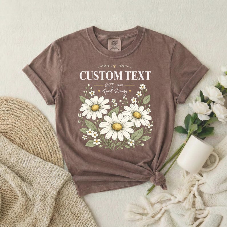 Custom daisy birth flower name tee in dusty mauve; relaxed unisex vintage shirt with white daisies, garment-dyed cotton.