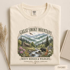 Nature tee featuring bears, wildflowers, stream, and misty mountain ridges