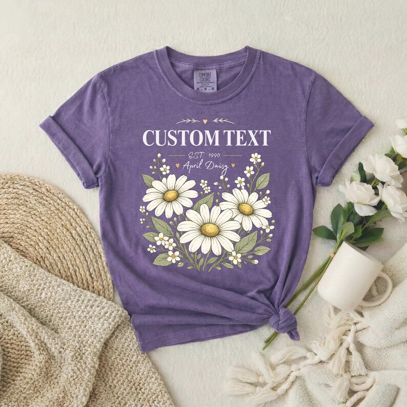 Purple unisex relaxed-fit tee with vintage birth flower tee and CUSTOM TEXT; white daisies with yellow centers, tied hem.