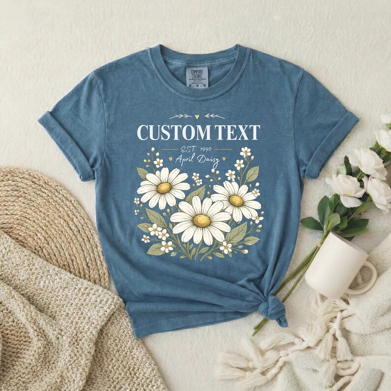 Custom daisy name shirt in blue ring-spun cotton; garment-dyed birth flower tee with daisies, vintage relaxed unisex fit.