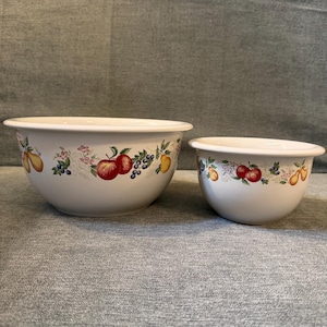 Puede incluir: Dos cuencos de cerámica blanca con un diseño de frutas y flores. Los cuencos presentan ilustraciones de manzanas, peras, uvas y flores. El cuenco más grande tiene unos 25 cm de diámetro, y el más pequeño, unos 15 cm.