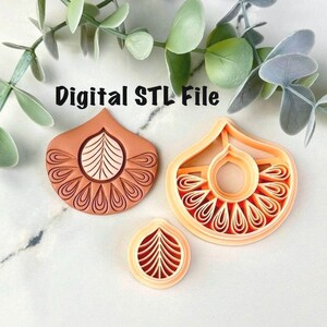 Pode incluir: Três cortadores de biscoitos cor de bronzeado com um design floral. Os cortadores têm a forma de uma lágrima com um padrão de folha central e uma borda decorativa. O texto "Digital STL File" está acima dos cortadores.