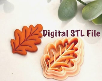 Può includere: Un tagliabiscotti a forma di foglia di quercia arancione e un biscotto finito a forma di foglia. Il tagliabiscotti è realizzato in plastica e presenta un design dettagliato. Il testo "Digital STL File" è visualizzato nell'immagine.